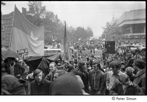 MIT war research demonstration: demonstrators marching with signs and an NLF flag