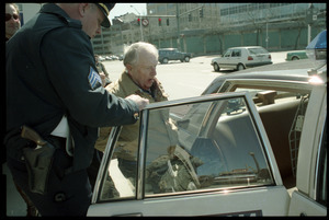 Elderly man with bloodied head (Wilfrid Lapierre) being arrested and put into patrol car by two policemen after protesting the banking crisis