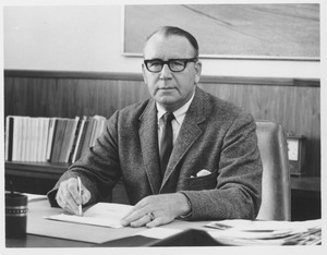 Warren Pierce McGuirk, sitting at desk with pen in hand