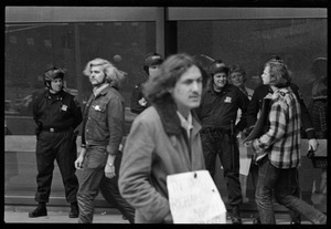 Police watch as antiwar demonstrators picket in front of the John F. Kennedy Federal Building