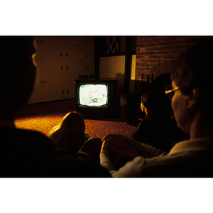 People gathered around a television set