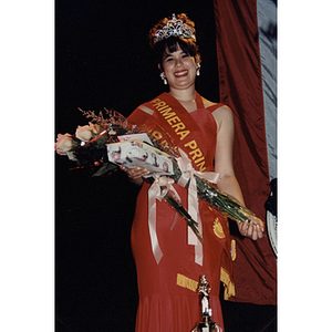 Chamely Toro wears a crown and holds a bouquet of roses at the Festival Puertorriqueño