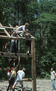 Henry Art nailing last rafter on north end of barn at the Moon Barn Raising at entrance to Hopkins Forest on 2 August 1975.