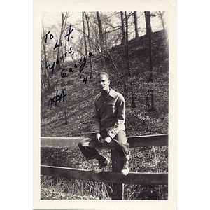 George Collins sits on a wooden fence