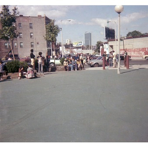 People seated, standing, and talking in small groups in the distance, at a Latino street festival