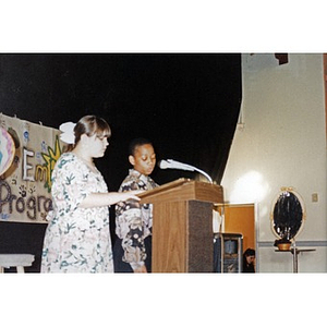 Boy and girl at the podium addressing the audience at a Teen Empowerment Program event.