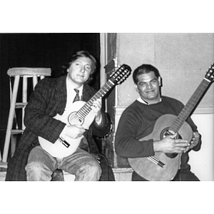 Claudio Ragazzi (left), Inquilinos Boricuas en Acción's Director of Arte y Cultura, playing a cuatro and sitting next to an unidentified man playing a guitar.