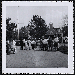 People gather in front of a jewelry shop in a plaza to watch a performance