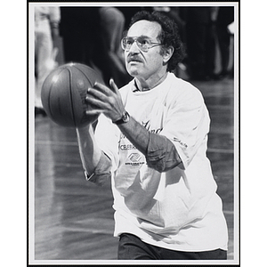 Harvard law professor and lawyer Alan Dershowitz holding a basketball ready to shoot at a fund-raising event held by the Boys and Girls Clubs of Boston and Boston Celtics