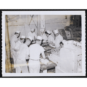 Members of the Tom Pappas Chefs' Club work with staff in a kitchen