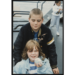 Two children pose on the deck of a boat