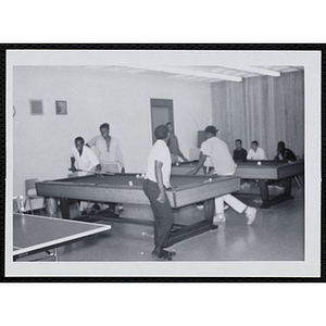 Group of teenagers playing pool in the game room