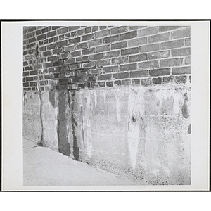 Deteriorating brick wall with water stains and cracks outside the Charlestown Boys' Club building