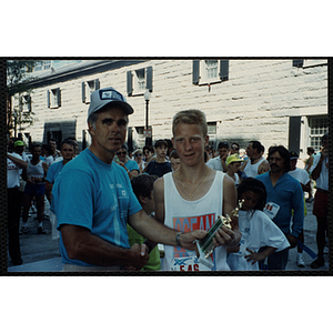 A man and boy pose with a trophy as they shake hands during the Battle of Bunker Hill Road Race