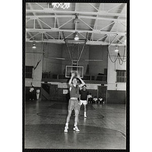 A teenage boy shoots a free throw during a basketball game