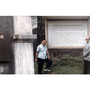 Two Association members pose in front of a Chinese sign