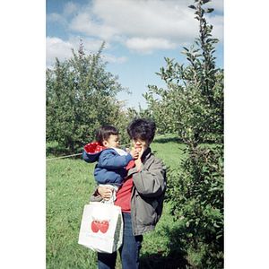 Woman eating in an orchard on a Chinese Progressive Association trip