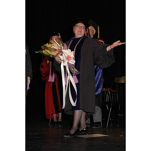 Faculty member poses with flowers at School of Nursing convocation