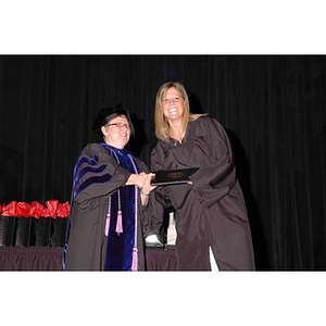 Faculty member presents student with gift bag at School of Nursing convocation