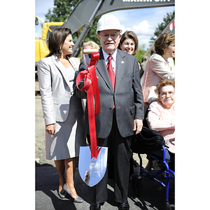 George J. Kostas stands holding a shovel at the groundbreaking ceremony for the George J. Kostas Research Institute for Homeland Security