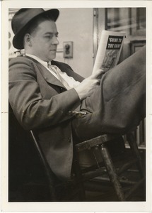 Photograph of Don Sullivan leaning back in a chair, reading