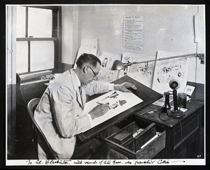 Franklin P. Collier, Boston Traveler cartoonist, drawing at his desk