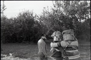 Commune members embracing, with apple buckets on their heads