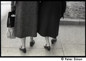Two older women walking on a sidewalk