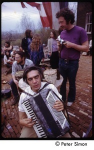 Harry Saxman (purple shirt) with man playing an accordion at May Day celebration, Packer Corner's commune