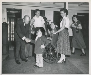 Jeremiah Milbank shakes hands with little person