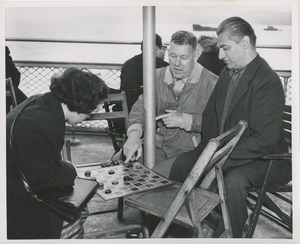 Men and woman playing checkers on boat ride