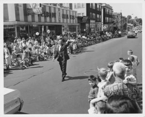 John Joseph Moakley walking and waving to crowd at a parade in South Boston (MA), 1960s