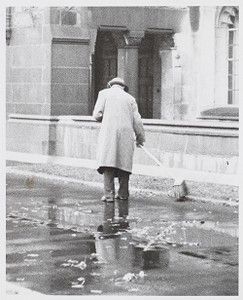 Man sweeping puddles on a rainy day at Boston College