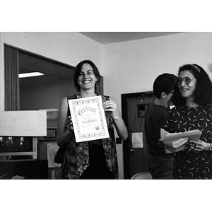 Inquilinos Boricuas en Acción staff member Laura Buxbaum holding up a Certificate of Recognition.