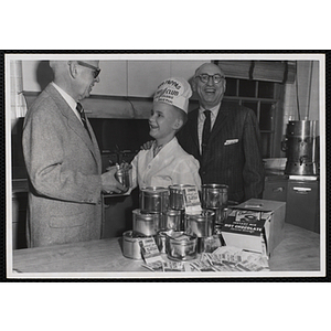 "James J. O'Brien of the Edmonds Coffee Co. donates coffee and cocoa to the cooking class of the Boys' Club as Chefs' Club memeber Herbert Doherty and Joe Margolis, Chairman of Advisory Committee, look on