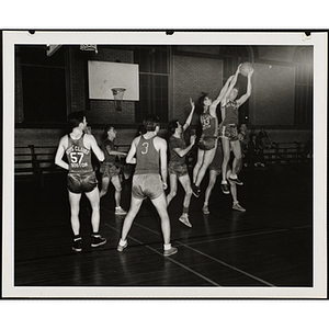 A player contests a shot near the goal during a basketball game