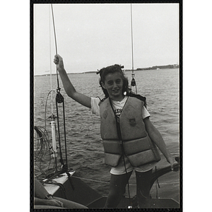 A girl stands on the deck of sailboat on Boston Harbor