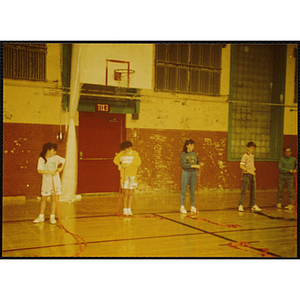 Five children put on safety harnesses in a gymnasium