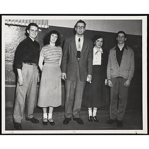 Three men and two young women pose in a line in front of a wall during a Boys & Girls Club event