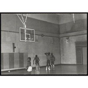 Men and boys play basketball in a gymnasium