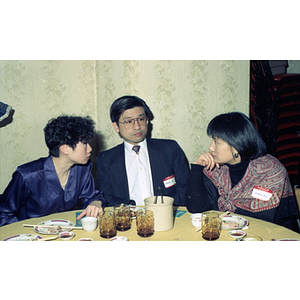 Man sits with two women at a restaurant table during a celebration of the Chinese New Year