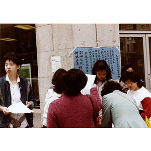 Community members on the corner of Beach Street and Harrison Avenue in Chinatown sign a petition on behalf of Long Guang Huang