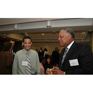 Torch Scholar Odalis David Polanco stands with a man at the Torch Scholars dinner