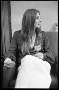 Judy Collins: three-quarter length portrait,seated in a chair with spray of flowers