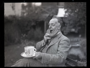 Henry A. Ellis and the doughnut: Ellis, seated, eating an oversized donut