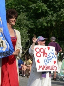 Parade marchers with banner for the Unitarian Universalist meetinghouse and sign celebrating same sex marriage '896 gaily married' : Provincetown Carnival parade