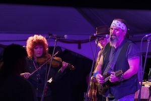 Steve Earle (guitar), Chris Masterson (partially obscured), and Eleanor Whitmore (fiddle) performing onstage with Steve Earle and the Dukes at the Payomet Performing Arts Center