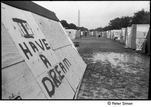 Plywood 'tent' with 'I have a dream' spray-painted on the side and the Washington Monument in the distance, Resurrection City