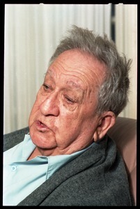 Fine art photographer Aaron Siskind: close-up portrait, while seated in a armchair in his living room