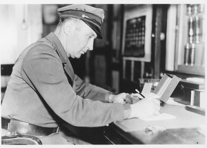 Campus police officer Tom Moran at a desk writing